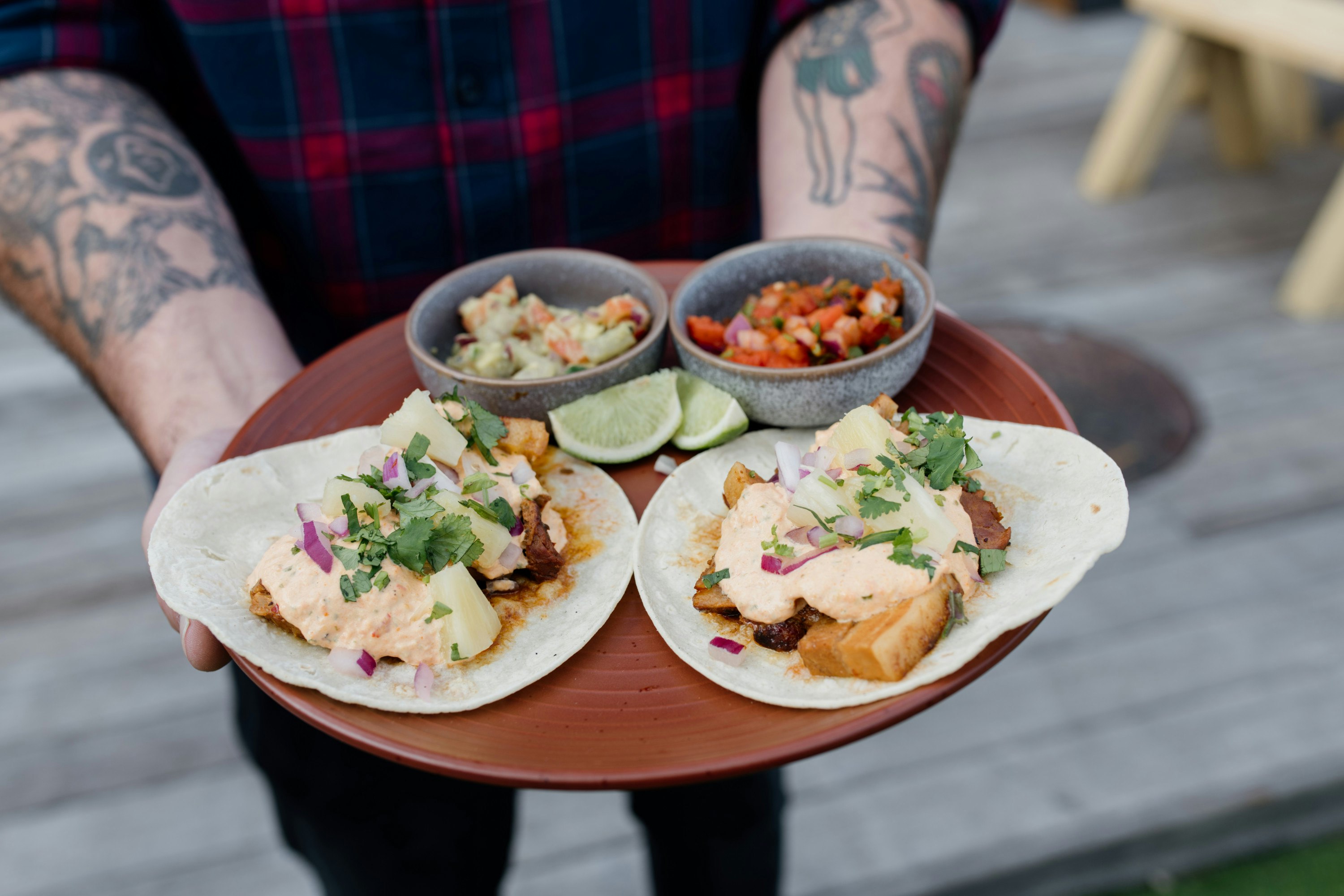 someone holding a plate of tacos